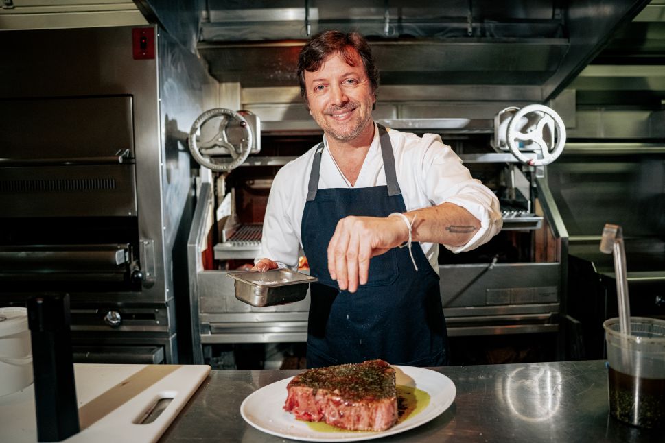 A chef seasoning steak.