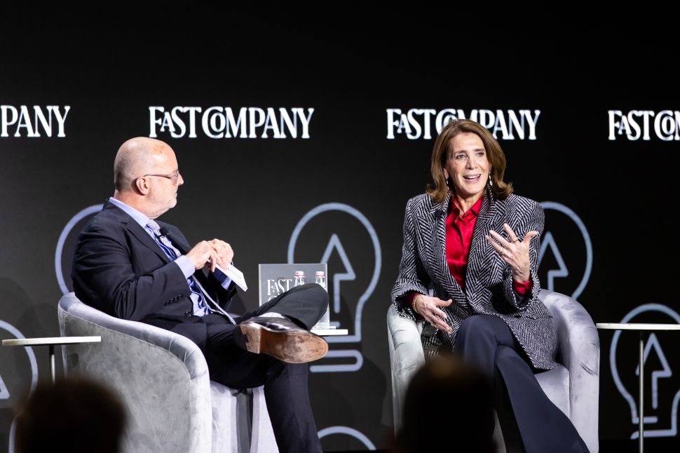 A man and a woman sit for an onstage interview