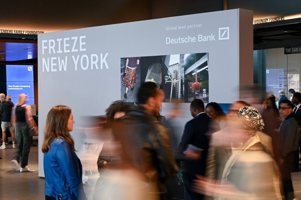 A busy entrance area at Frieze New York shows visitors moving past a large fair sign with Deutsche Bank branding.