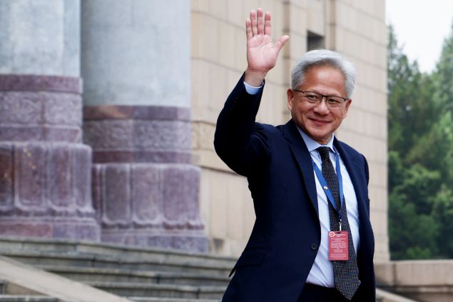Man in suit waves to camera
