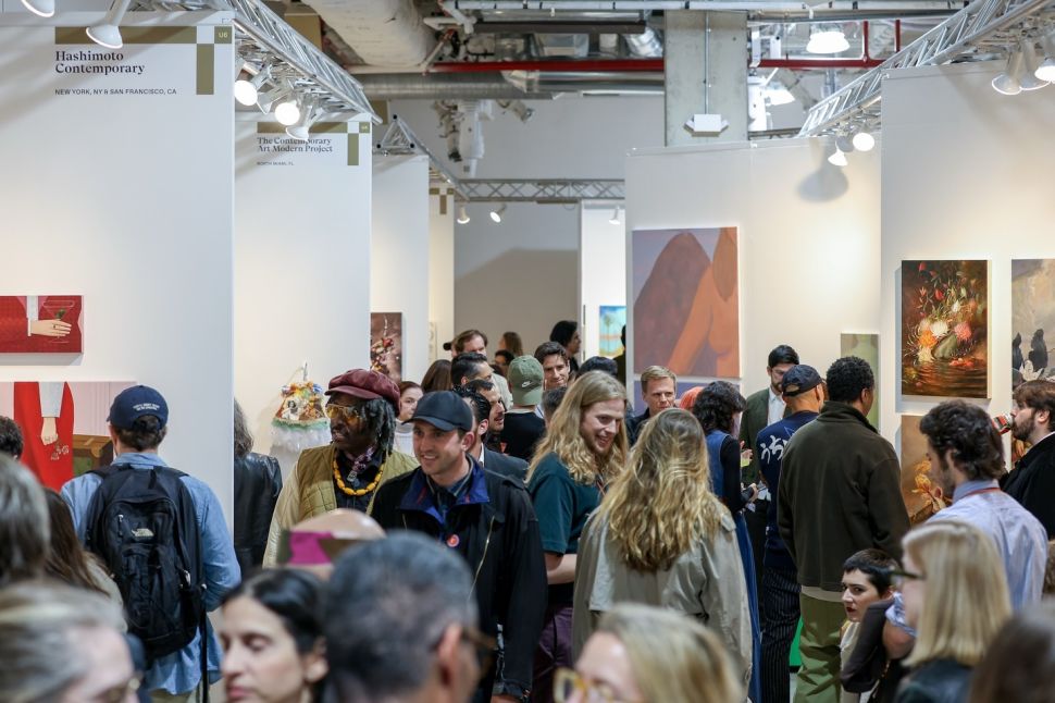 A crowded Future Fair aisle shows visitors moving between gallery booths displaying paintings and sculptural works.