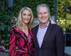 Woman in red dress and man in suit pose together outside