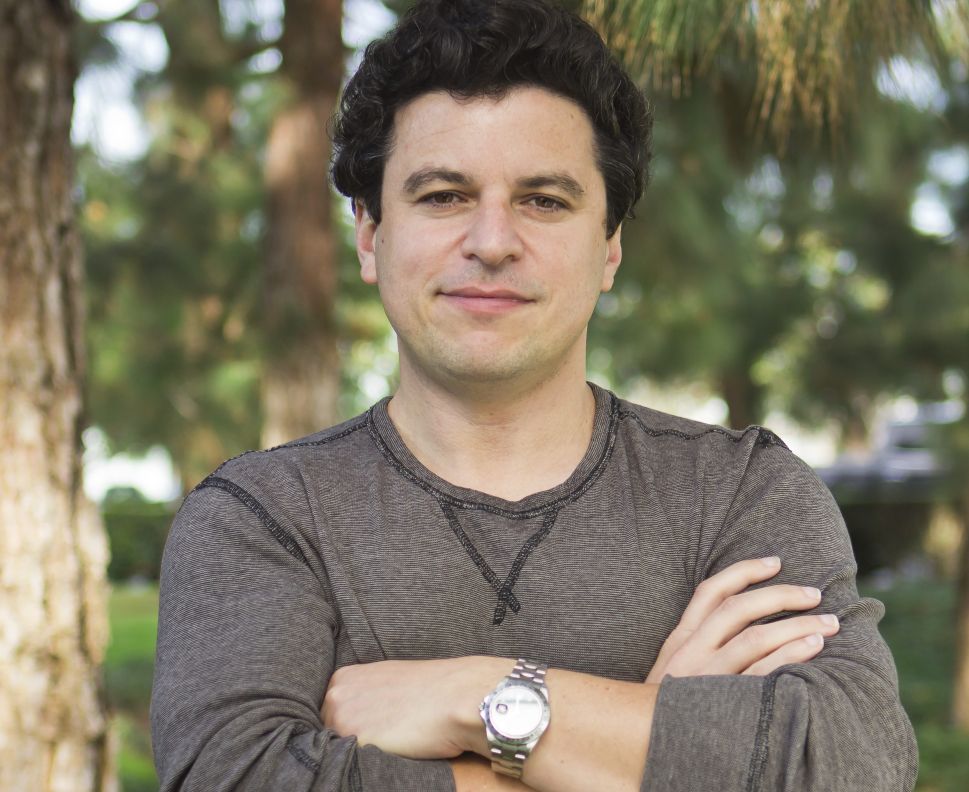 Noah Kerner, CEO of Acorns, standing outdoors with his arms crossed