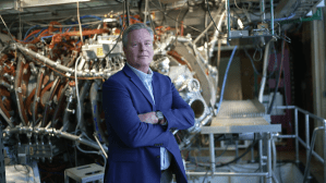 A White man in a blue suit posing for a photo.